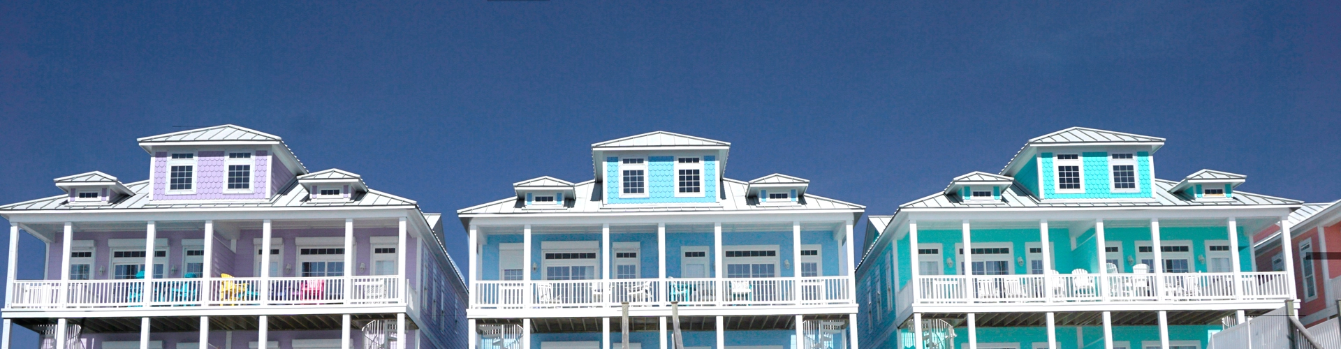 Three colorful buildings with white aluminum roofing material